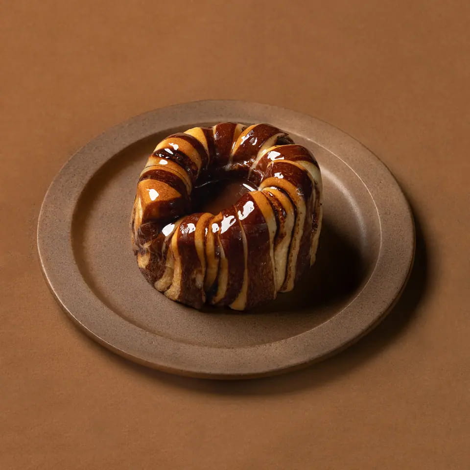 Chocolate babka ring with glossy chocolate swirls on a stoneware plate