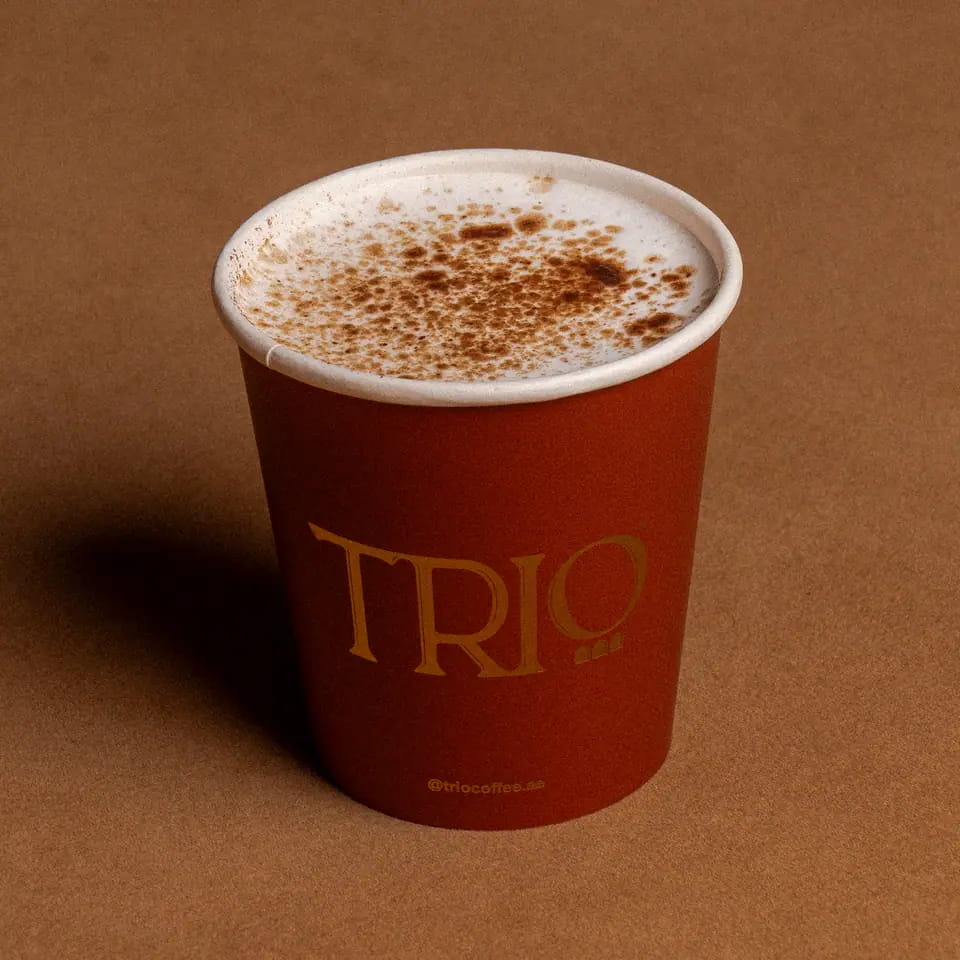 Babyccino dusted with cocoa in a TRIO paper cup
