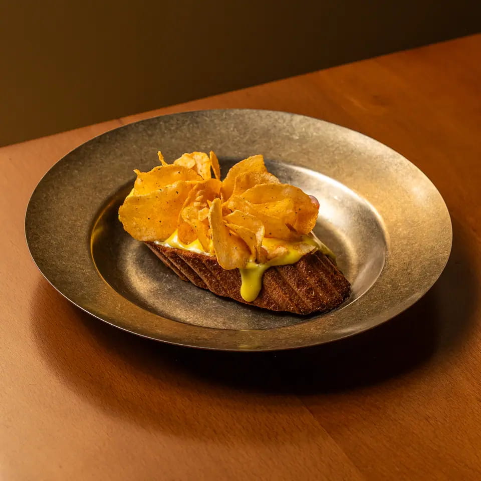 Cheese and chips toast on a brass plate