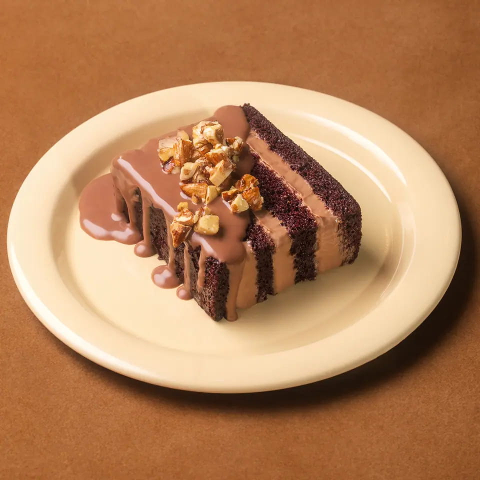 Layered chocolate cake with chocolate sauce and caramelised nuts