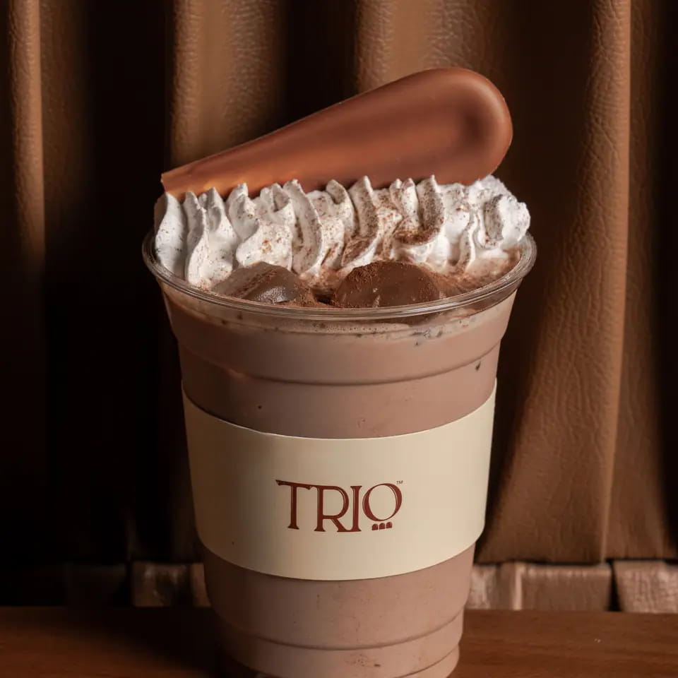 Cold chocolate with whipped cream and a chocolate tuile in a TRIO cup
