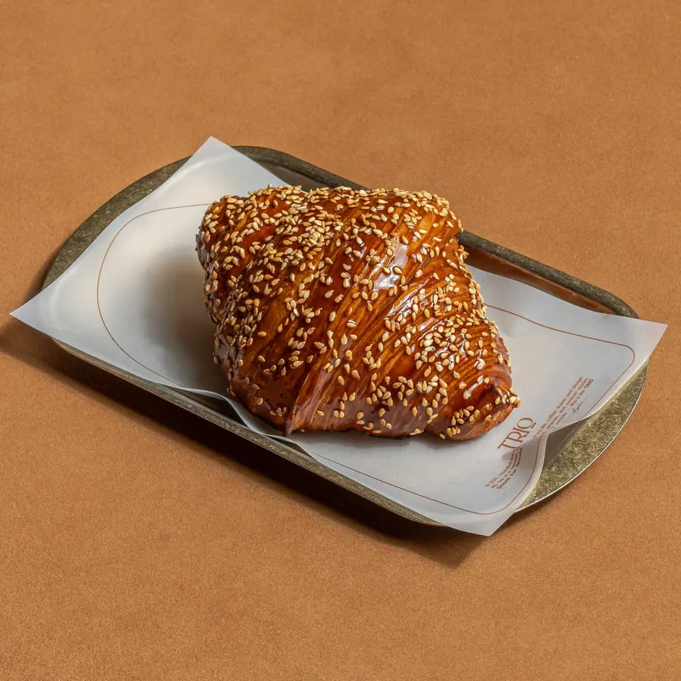Sesame-crusted dates and cheese croissant on a lined tray
