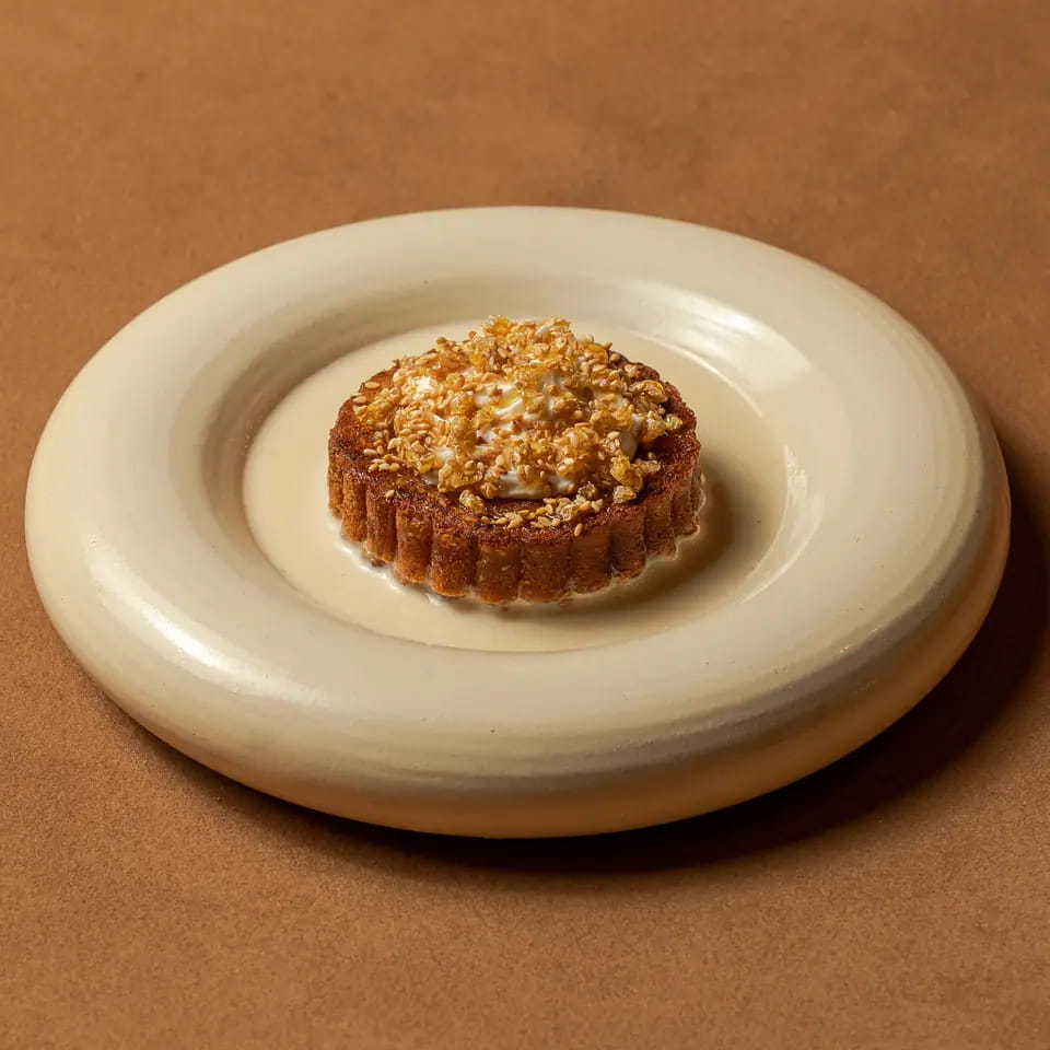 Honeycomb cheese toast with sesame praline on a cream ring plate