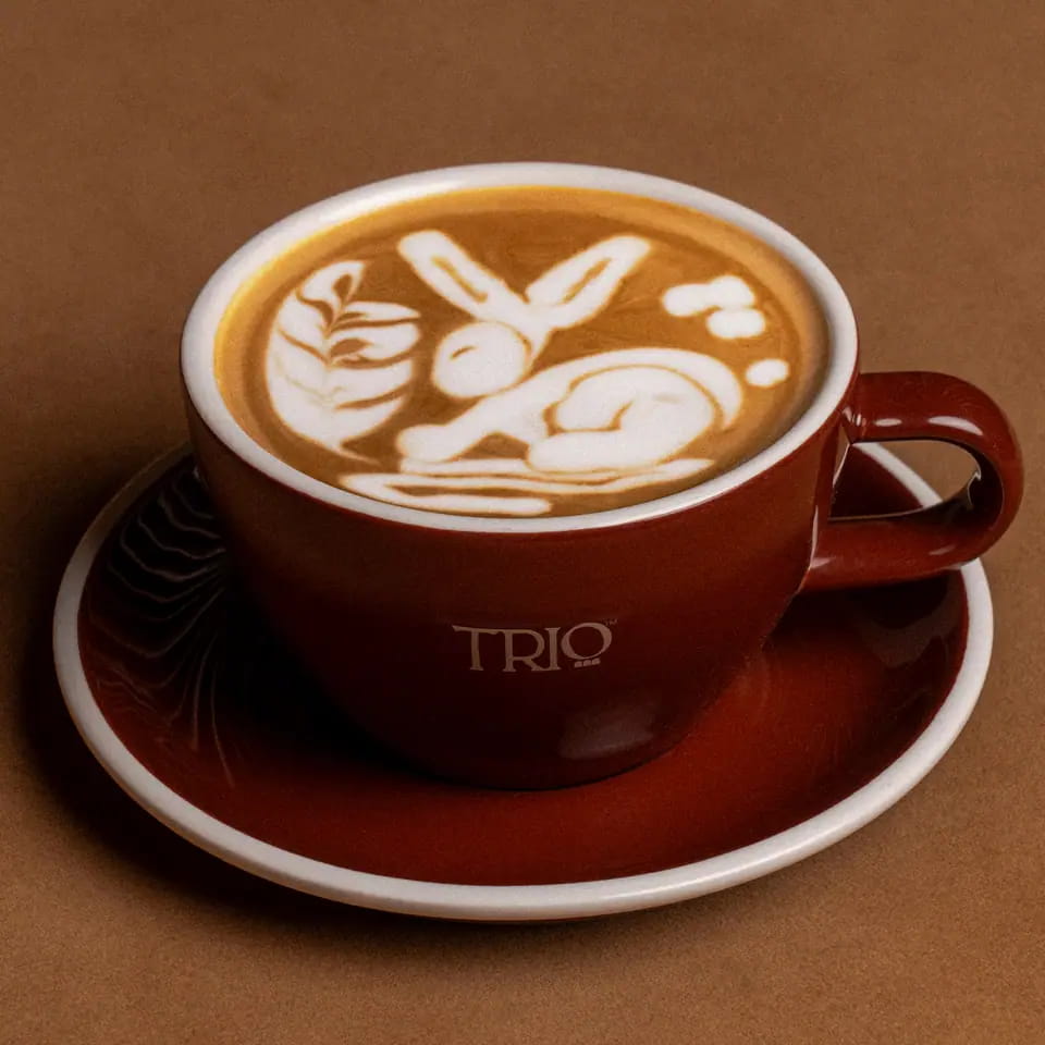 Hot latte with rabbit latte art in a burgundy TRIO cup