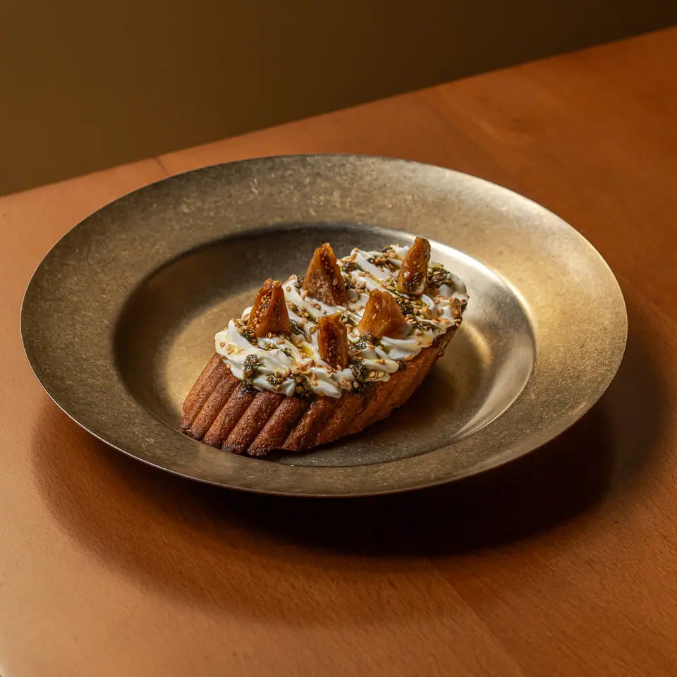 Labneh zaatar toast with toppings on a brass plate