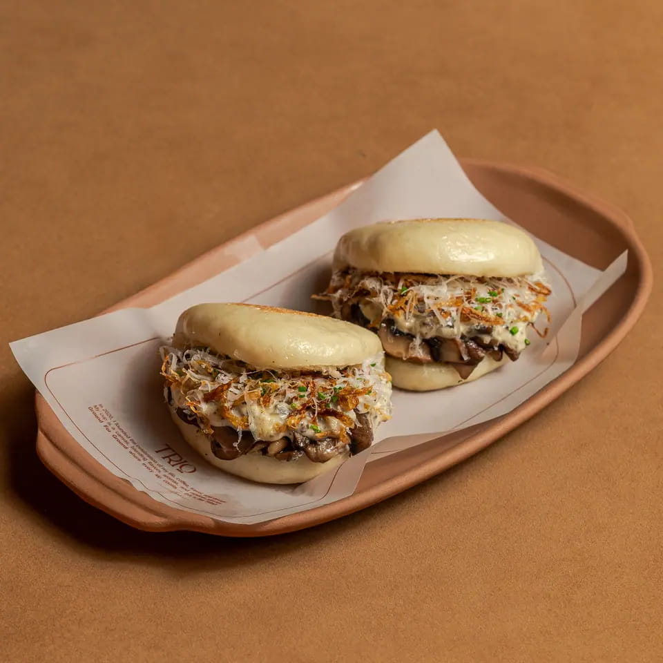 Two mushroom truffle bao buns on a lined tray