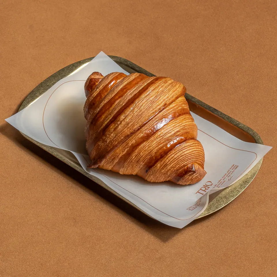 Plain butter croissant on a TRIO paper-lined tray