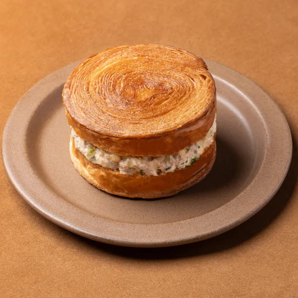 Spicy tuna in a laminated pastry round on a stoneware plate